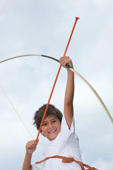 Happy little boy playing with bow and arrow