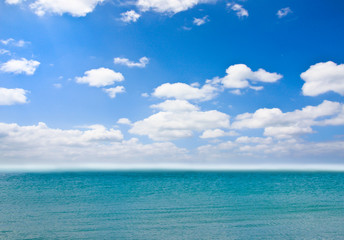 Naklejka na ściany i meble Cloudy blue sky over the sea