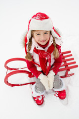 Happy winter - portrait of little girl  on sledge