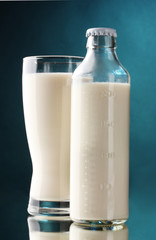 bottle and glass of milk on blue background