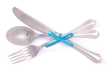 Silver fork and spoon, knife tied with a blue ribbon isolated