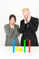 business team looking collapsed building block