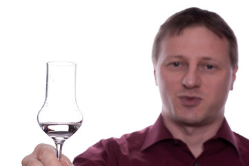 Mann prostet mit einem Glas Schnaps