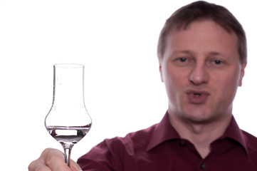 Mann prostet mit einem Glas Obstbrand