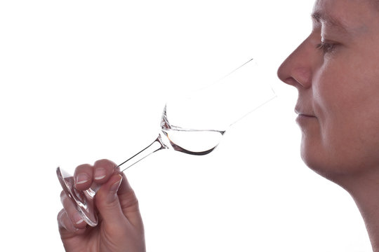 Frau riecht an einem Glas Grappa