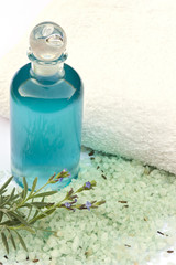 Lavendel, Öl in Flasche, Zweig mit Blüten vor Handtuch