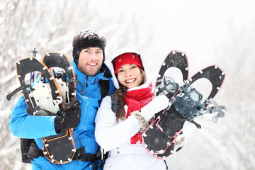 Winter couple outdoors on snowshoes - Powered by Adobe