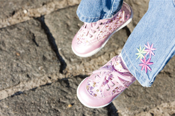detail of sitting girl wearing pink shoes