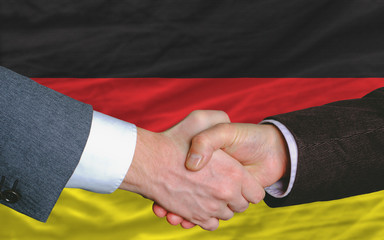 businessmen handshake after good deal in front of germany flag
