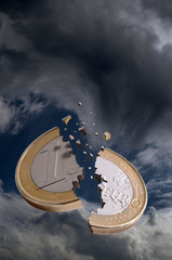 A one euro coin is broken in a stormy sky - 37893626