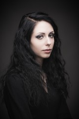 Fototapeta premium Young attractive gothic brunette woman over black