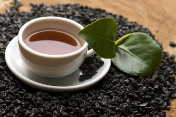 A cup of green tea with freh leaves
