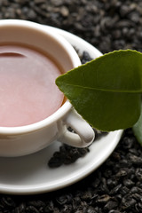 A cup of green tea with freh leaves