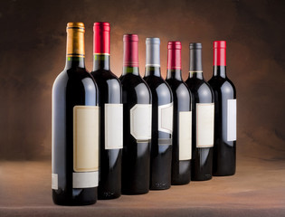Red wine bottles in a row with empty labels