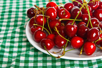 plate on the green cloth, with juicy cherry