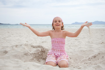 Fototapeta na wymiar little girl playing in sand