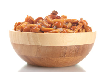 Marinated mushrooms in wooden bowl isolated on white