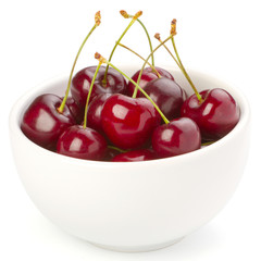 Red ripe cherries in a bowl on white background