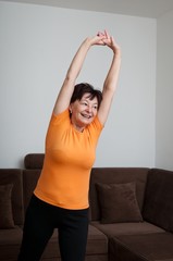 Fototapeta na wymiar Senior fitness woman exercising at home