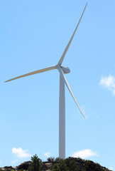 Wind power station - wind turbine against the blue sky