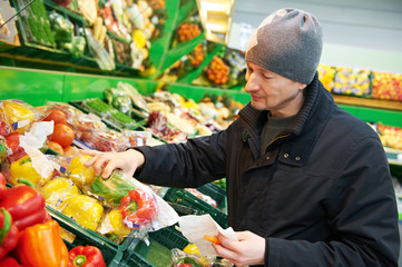 woman choosing vegetables in supermarket store