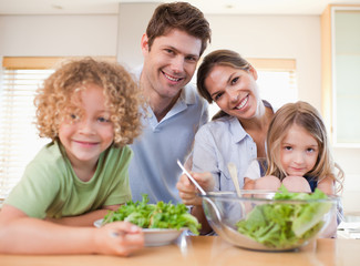 Smiling family preparing a salad together