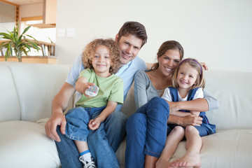 Smiling family watching TV together