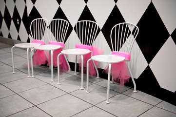 Row of White Chairs with Pink Ribbons