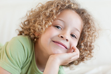 Close up of a smiling boy lying on a sofa