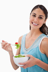 Portrait of a young woman eating a salad