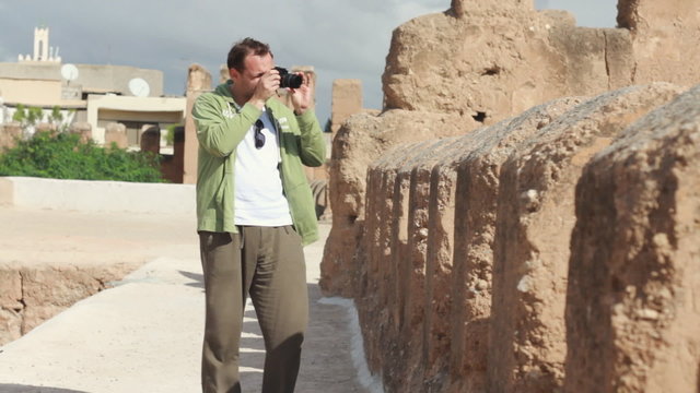 Male tourist taking photo of ancient walls