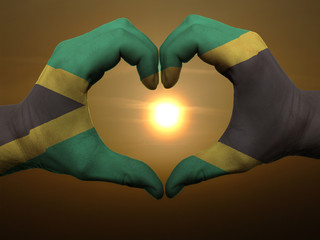 Heart and love gesture by hands colored in jamaica flag during b - obrazy, fototapety, plakaty
