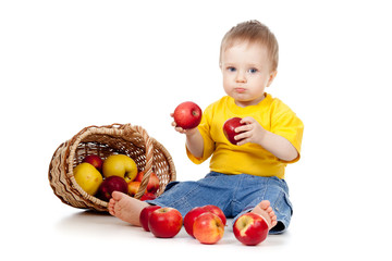 Fototapeta na wymiar child eating red apples; near basket