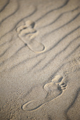 Fototapeta na wymiar Two human footprints on the beach sand