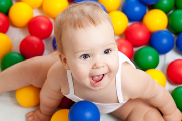 Fototapeta na wymiar Portret adorable niemowlęcia siedzi wśród kolorowych kulek