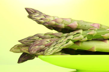 delicious asparagus on plate on  green background
