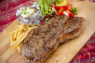 steak set, set of steak with salad, fries and baked potato.