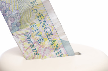 Five pound note & piggy bank.