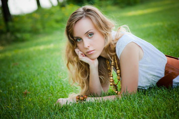 Obraz premium Beautiful girl lies on the grass