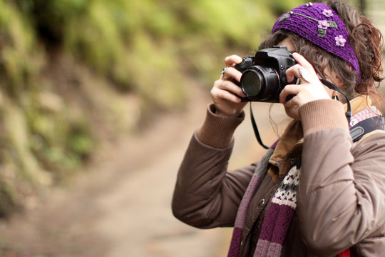 Young woman taking pictures with an SLR camera.