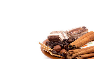 Sweets, cinnamon, nuts and coffee beans on a saucer