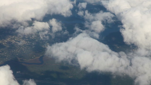 Flying above clouds and land, airplane shot
