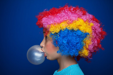 Young girl blowing bubble gum balloon