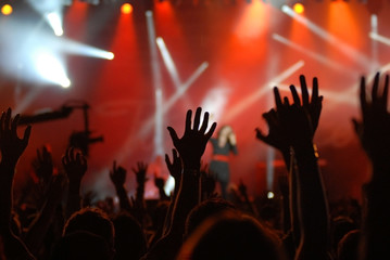 Fototapeta na wymiar raised hands at concert with red lighting