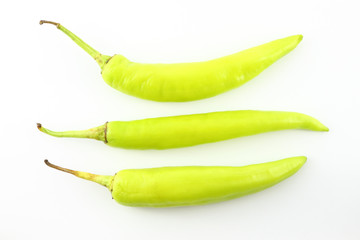 Three green chili peppers on white background.