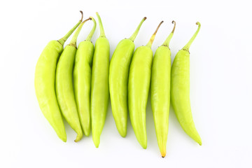 Multiple green chili peppers on white background.