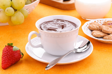 Cioccolata in tazza con biscotti, latte e frutta