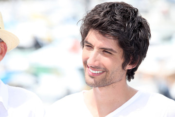 Dark haired man in white t-shirt stood outdoors