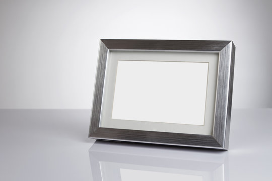 Blank silver picture frame at the desk with clipping path