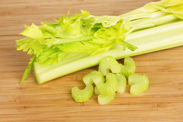 fresh slised green celery on wooden background.